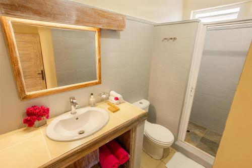 a bathroom with a sink and a toilet and a mirror at Cocotiers Hotel – Mauritius in Port Louis
