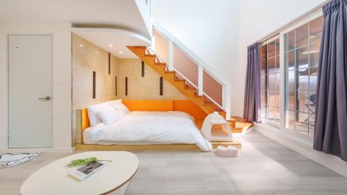 a bedroom with a bed with an orange headboard and a staircase at Gapyeong Santa Maria Dog-friendly Privat in Gapyeong