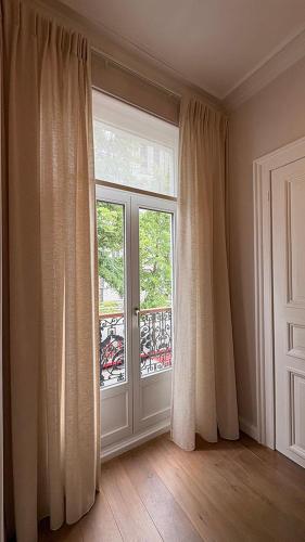 an empty room with a window and a door at Maison Martin 7 in Kortrijk