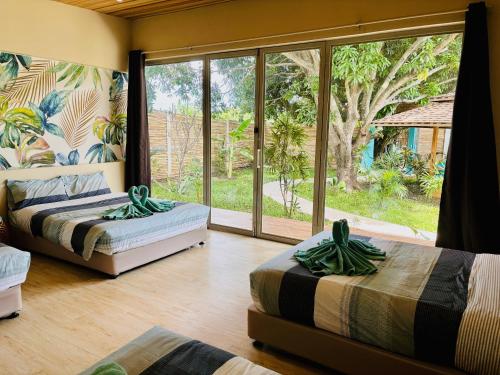 two beds in a room with a large window at Turquoise Villa in Floridablanca