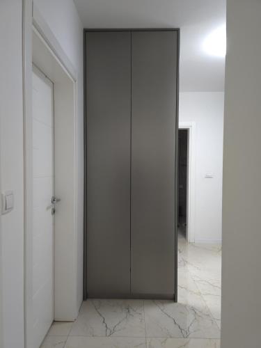 a black door in a room with white walls at Domatio Apartments in Novi Pazar