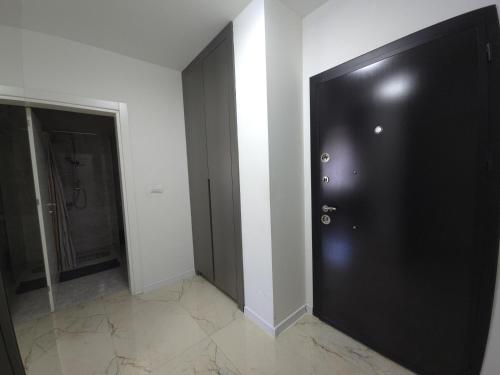 a black door in a room with a bathroom at Domatio Apartments in Novi Pazar