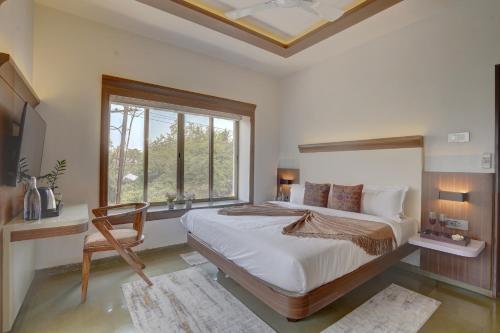 a bedroom with a large bed and a window at Tranquil 3 BHK Pet-Friendly Gateway with Bathtub, Balcony and Scenic Views in Lonavala