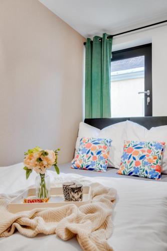 a bed with a tray with a vase of flowers on it at Muzealna Business Rooms in Opole