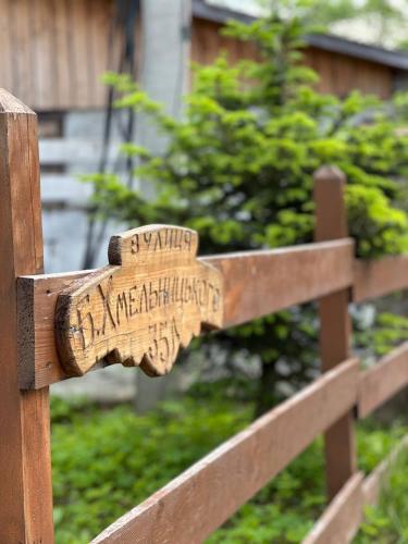 a wooden sign on a wooden fence at Dobriy Hotel in Vorokhta