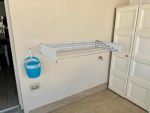 a kitchen with a white cabinet and a blue bucket at Alloggio Ulivi in Isola Rossa