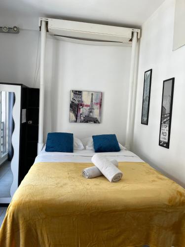 - une chambre avec un grand lit et 2 oreillers bleus dans l'établissement Hyper Center - Superb Studio - Cozy - Wifi, à Nice