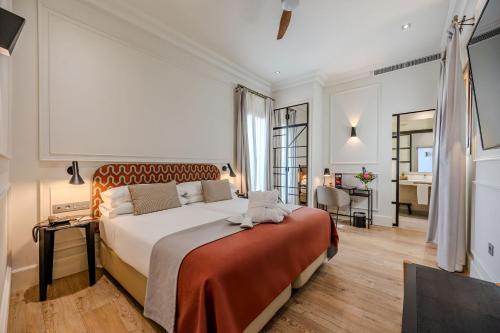 a bedroom with a large bed and a living room at Hotel Boutique Casa Romana Villa in Seville