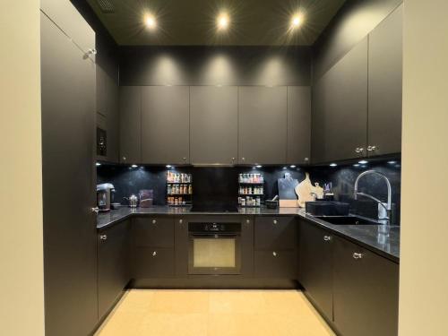 une cuisine avec des armoires noires et un comptoir dans l'établissement A beautiful designer apartment, à Cannes
