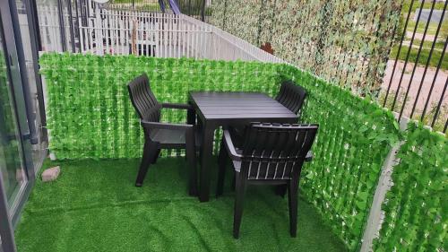 a table and two chairs on a balcony with green grass at BURABAY Promenade Solo in Borovoye