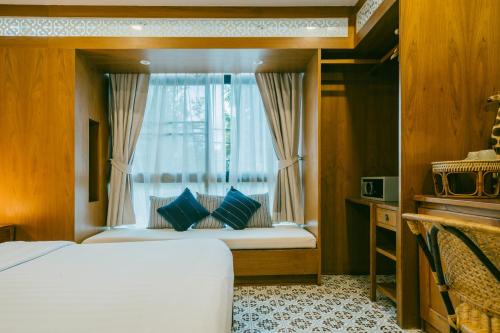 a bedroom with a bed with a window at Amaka Bed and Breakfast in Chiang Mai