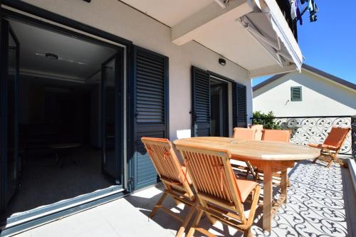 a wooden table and chairs on a patio at Djenovici Sunny port apartment in Ðenovići