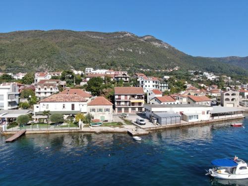 a town on the water with boats in the water at Djenovici Sunny port apartment in Ðenovići