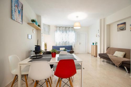 a living room with a table and chairs at Sofia Maisonette by RentalsPro - Sani Halkidiki in Sani Beach