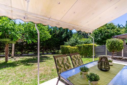 a table and chairs under an umbrella on a patio at Sofia Maisonette by RentalsPro - Sani Halkidiki in Sani Beach