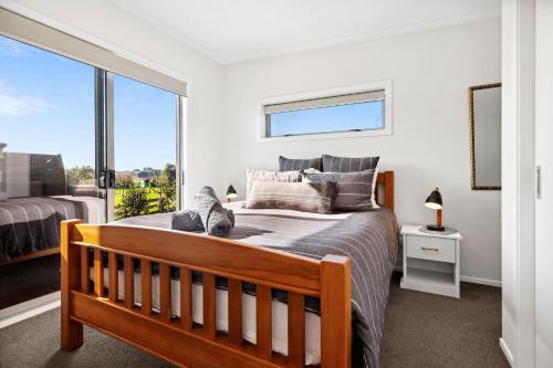 汉密尔顿Country Comfort - only 10 minutes from Hamilton CBD的一间卧室,卧室里配有一张床,猫坐在床上
