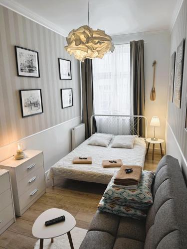 a small bedroom with a bed and a couch at Dobry Adres in Gdynia