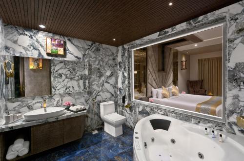 łazienka z wanną, umywalką i łóżkiem w obiekcie Saya Grand Resort By Treat Thane w mieście Dive