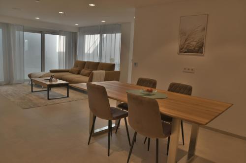 a living room with a wooden table and chairs at DonauDeluxe in Geisingen