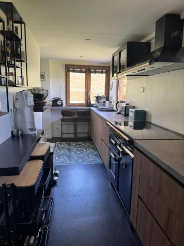 une cuisine avec des armoires en bois et un comptoir dans l'établissement Dans Chalet aux Chartreux - T4 Duplex 100m2 traversant Vue Lac - Fibre, Golf, à Tignes