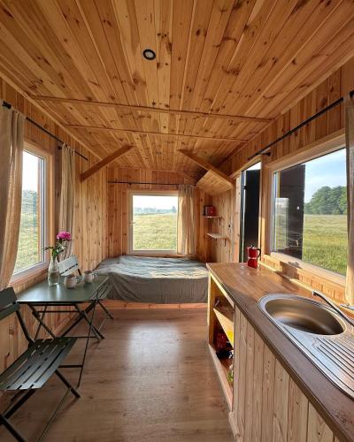 a kitchen with a sink and a bed in a room at Domek na łące in Daniec