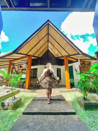 a woman walking in front of a house at Villa Amuntai in Dinalupihan