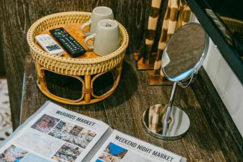 a table with a mirror and a basket and a magazine at Amaka Bed and Breakfast in Chiang Mai