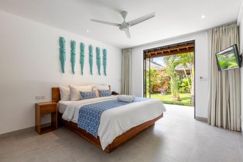 a bedroom with a bed and a sliding glass door at Nature's Immersion Room at Anwa Bali Boutique Resort in Canggu