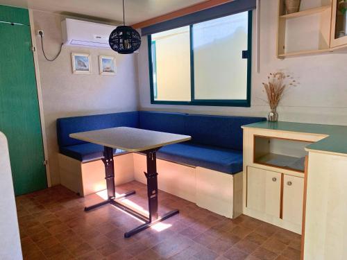 a table and a blue bench in a kitchen at Comfortabele familie chalets met veranda incl airco dichtbij zee! in Viareggio