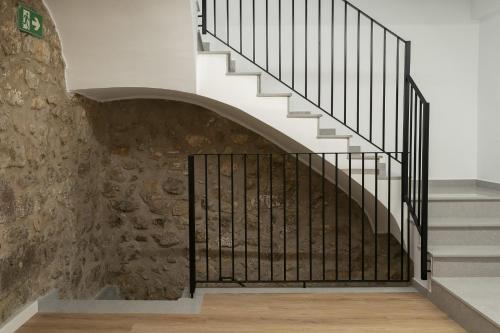 a staircase with wrought iron railings and a stone wall at Casa Castell Orangecosta in Peñíscola