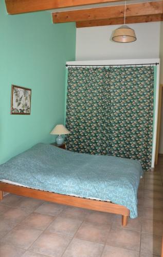 - une chambre avec un lit doté d'un couvre-lit vert dans l'établissement Maison sous les chênes, à Saint Alban Auriolles