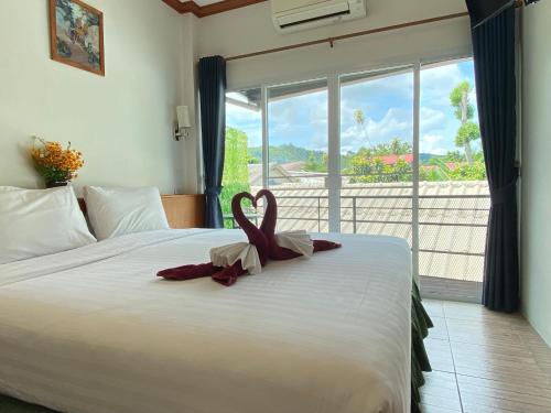 a bedroom with a bed with a heart decoration on it at The Golden Beach Resort Naiyang in Nai Yang Beach