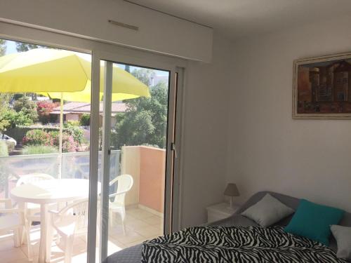 Cette chambre dispose d'un lit et d'une terrasse avec une table. dans l'établissement Appartement 6 personnes à Saint Raphaël Valescure Piscine Tennis Pétanque, à Saint-Raphaël