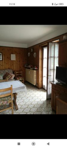 a bedroom with a bed and a tv in a room at Mizoun Paola Via Roma 9 in Aisone