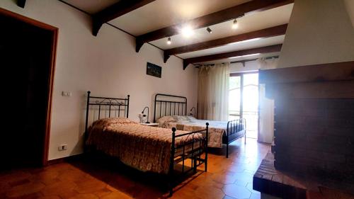 a bedroom with two beds and a large window at Mizoun Paola Via Roma 9 in Aisone