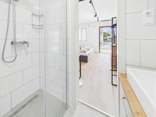 a bathroom with a glass shower and a tub at Apartmani Jesenova in Selce