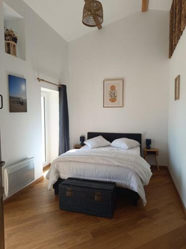 une chambre avec un lit dans une pièce blanche dans l'établissement la JOLLY maison, à Épargnes