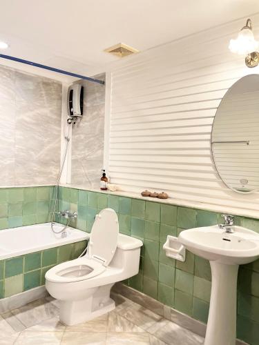 a bathroom with a toilet and a sink and a mirror at บ้านมนชเลชะอำ ติดชายหาด Baan Monchale in Ban Sa