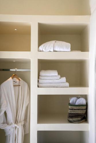 a closet with white towels and a bed at Anthea Hotel in Tinos Town