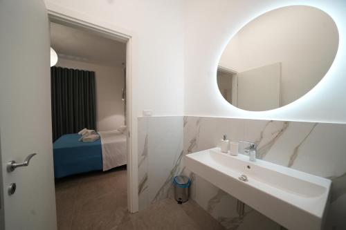 a white bathroom with a sink and a mirror at Bed and Breakfast Il Giardino in Amantea