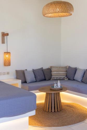 a living room with a blue couch and a table at Anthea Hotel in Tinos Town