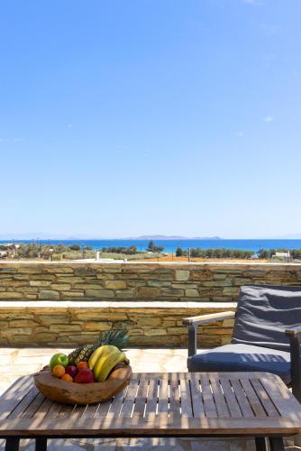 a bowl of fruit on a table next to a chair at Anthea Hotel in Tinos Town