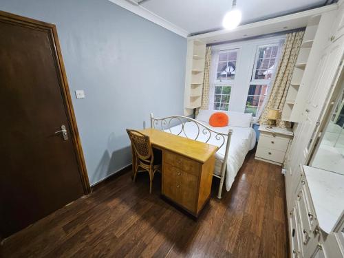 a bedroom with a bed and a desk and a table at SnoozeDen Wellesley - Near to Slough Station in Slough