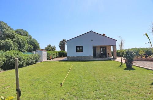 ein Haus mit einer großen Wiese davor in der Unterkunft Casa Marcucaña el Palmar in El Palmar