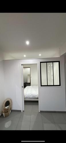 une chambre blanche avec un lit et une fenêtre dans l'établissement T2 Perier 13008, à Marseille