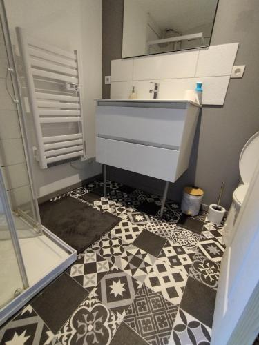 La salle de bains est pourvue d'un lavabo, de toilettes et de carrelage. dans l'établissement Jolie maison centre Ernée, à Ernée