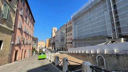a green car driving down a city street with buildings at Cleo Rosa in Ancona