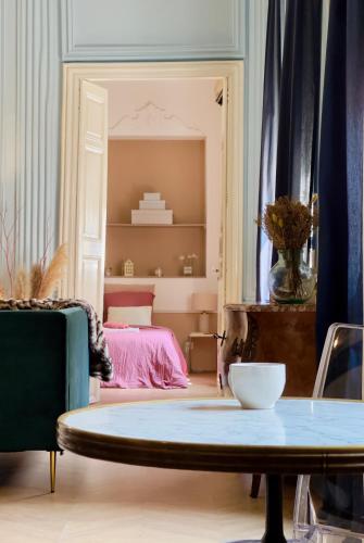un salon avec une table et un lit dans l'établissement Puddington Abbey by Art&Suites Élégant XVIIIe 80m privatif Centre ville Calme et douceur de vivre, à Narbonne