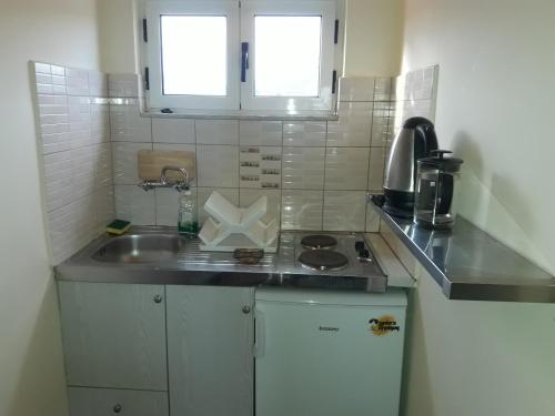 a small kitchen with a sink and a stove at olivensun studio 12 in Gythio