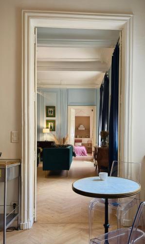 un salon avec une table et une chambre dans l'établissement Puddington Abbey by Art&Suites Élégant XVIIIe 80m privatif Centre ville Calme et douceur de vivre, à Narbonne